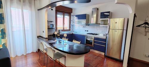 a kitchen with a black table and a refrigerator at La Casa di Edo in Verona
