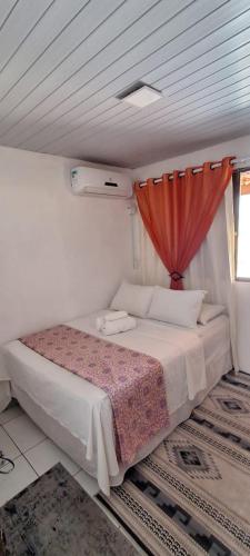 a bedroom with a bed with a red curtain at Vila dos Bangalôs in Barreirinhas