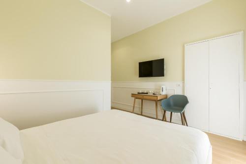 a bedroom with a bed and a desk and a television at Risorgimento 9 - Guest House in Rome
