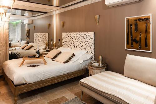 a bedroom with two beds and a couch at Love Room 1001 nuits & Balnéo in Saint-Rambert-dʼAlbon