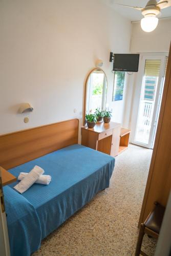a bedroom with a blue bed and a mirror at Hotel Singapore in Milano Marittima
