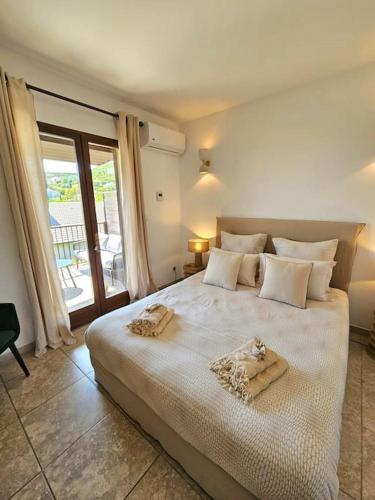 une chambre avec un grand lit blanc avec des serviettes dessus dans l'établissement Bel appartement avec piscine Cap Corse- Sisco, à Marine de Sisco
