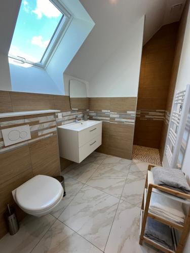 a bathroom with a white toilet and a sink at Belle maison au calme avec parking in Bretteville-sur-Odon