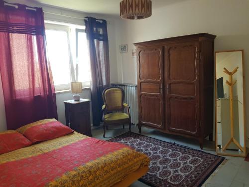 - une chambre avec un lit, une armoire et une chaise dans l'établissement Chez Nadine, à Thionville