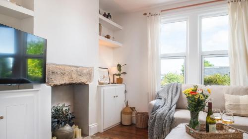 a living room with a couch and a tv at Lucknow Cottage in Stroud