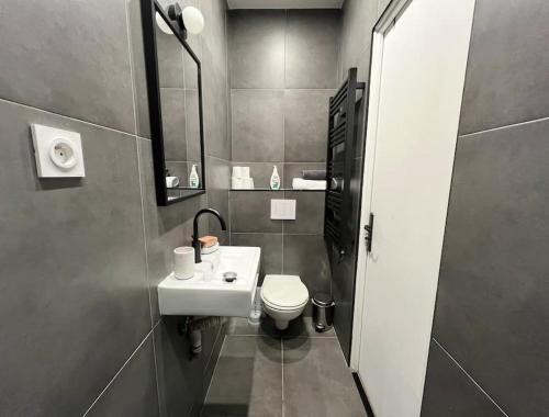 une petite salle de bain avec un lavabo et des toilettes dans l'établissement Le Cosy Parisien - Au cœur du 13ème - 14MB, à Paris