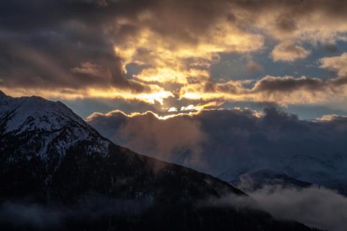 a sunset over a mountain range with clouds in the sky at Berggasthof Hochzeigerhaus in Jerzens