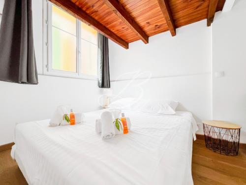 une chambre avec un lit blanc avec des serviettes dessus dans l'établissement Le Voilier - Appartement Confortable Centre Cannes, à Cannes