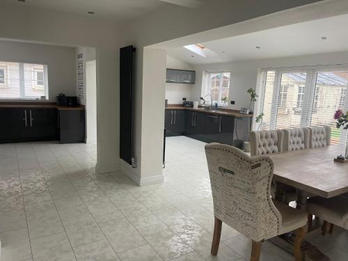 a kitchen and dining room with a wooden table and chairs at Hidden beauty in peaceful place in Peterlee