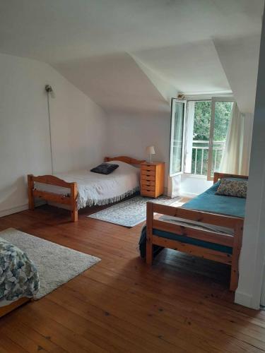 une chambre avec deux lits et une fenêtre dans l'établissement Gîte nature à La Chapelle de Brain, à La Chapelle-de-Brain