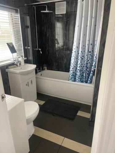 a bathroom with a tub and a toilet and a sink at Hidden beauty in peaceful place in Peterlee