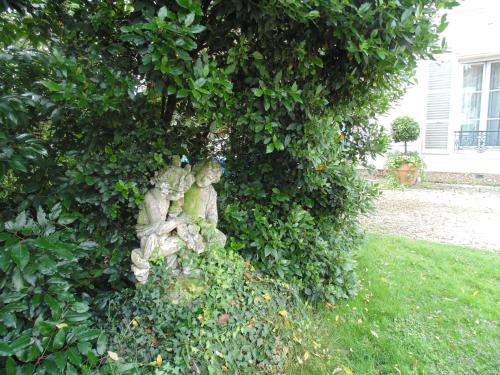 two statues of people sitting in a bush at Clos Saint Nicolas in Neauphle-le-Château