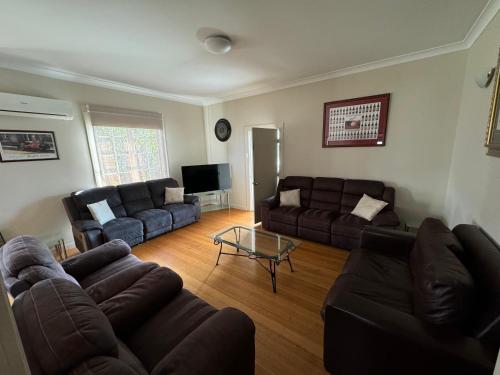 a living room with two couches and a television at Penfold Cottage CBD Launceston Invermay in Launceston