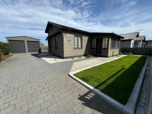 a small house with a lawn in front of it at Penfold Cottage CBD Launceston Invermay in Launceston