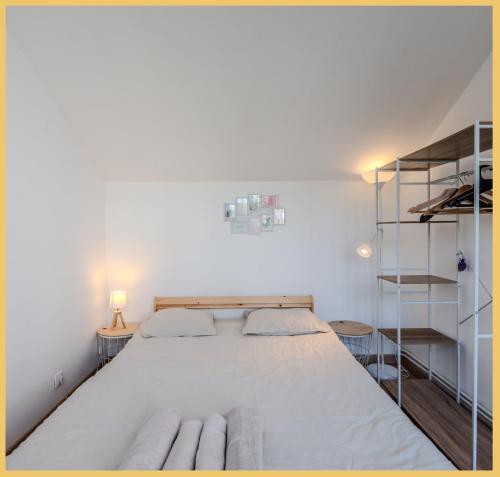 - une chambre avec un grand lit blanc et des étagères dans l'établissement Chez Amel & Val I T2 I Annemasse, à Annemasse