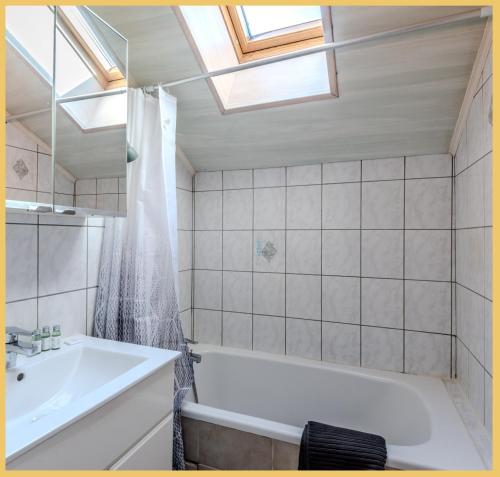 une salle de bain avec une baignoire blanche et un lavabo dans l'établissement Chez Amel & Val I T2 I Annemasse, à Annemasse