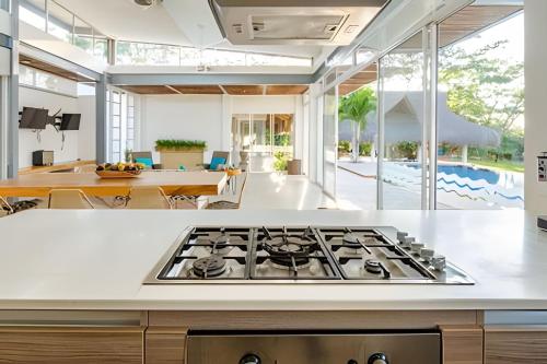 a kitchen with a stove top oven in a room at Modern & fresh | Villa Arroyito w/Pool & Barbecue in Cartagena de Indias