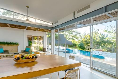 a dining room with a table and a pool at Modern & fresh | Villa Arroyito w/Pool & Barbecue in Cartagena de Indias