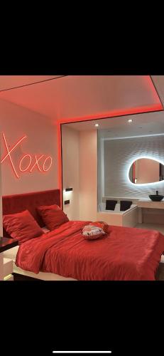 - une chambre avec un lit rouge et un grand miroir dans l'établissement Love room, à Chennevières-sur-Marne
