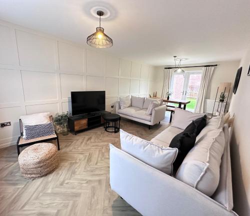 a living room with a couch and a tv at Durham Holiday Home in Durham