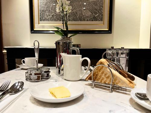 a table with plates of food and a vase with cheese at London Bridge Hotel in London