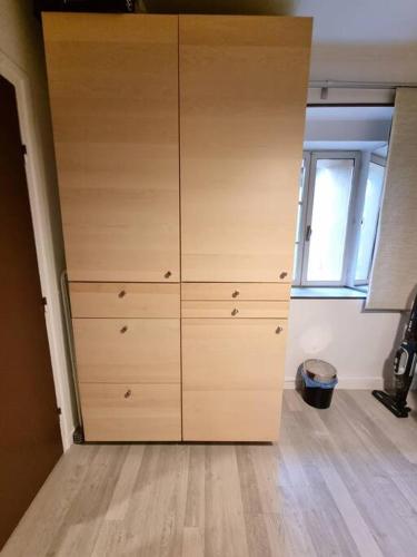 Cette chambre dispose d'une grande armoire en bois et d'une fenêtre. dans l'établissement Le Balme #Calme#Confort#Quartier Historique, à Clermont-Ferrand