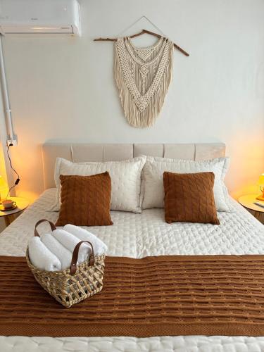 a bed with a basket of towels on it at Granbalaio Hostel in Blumenau