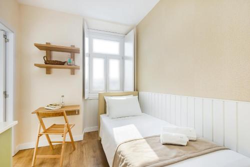 a small room with two beds and a table at Metropolitan Living Lisbon - Campolide in Lisbon