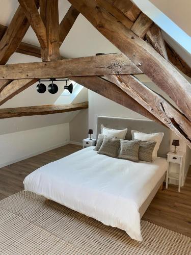 - une chambre avec un grand lit blanc et des plafonds en bois dans l'établissement Farmhouse of Château de La Motte-Feuilly, à La Motte-Feuilly