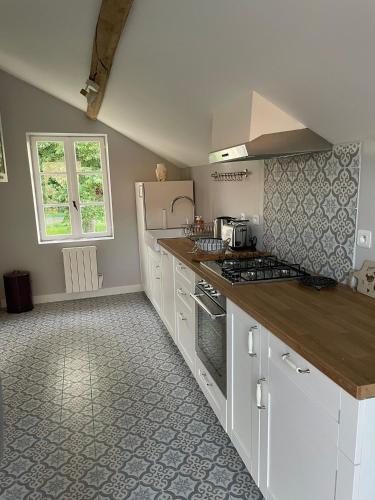 une cuisine avec des armoires blanches et un comptoir dans l'établissement Farmhouse of Château de La Motte-Feuilly, à La Motte-Feuilly