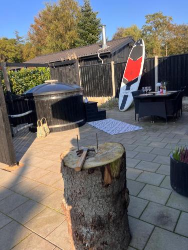 a tree stump with a table in a backyard at Huset ved søen tæt på Herning og MCH og boxen 90 m2 in Sunds