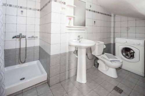y baño con aseo, lavabo y lavadora. en Villa Koule, en Kalami
