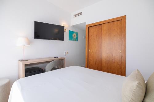 a bedroom with a bed and a wooden door at JS Miramar in Can Picafort