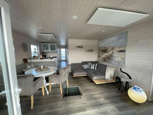 a living room with a couch and a table at Hausboot Sophie in Stralsund in Stralsund