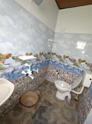 a bathroom with a toilet and a sink at Lara Homestay in Gonebidu
