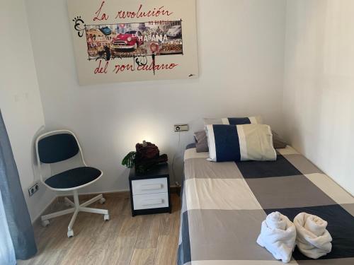 a bedroom with a bed and a chair and a picture at Apartamento 2 habitaciones ZEN in Deltebre