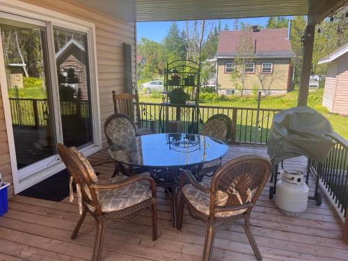 a patio with a table and chairs on a porch at Chalet Mathis in Saint-Raymond