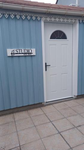 un garage avec une porte blanche et un panneau sur celui-ci dans l'établissement Le Studio, à Aubervilliers