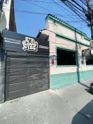 a building with a garage door with a sign on it at L a Good Vibe in Utinga