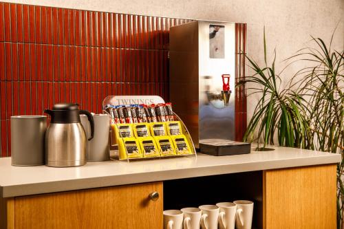 a kitchen counter with a coffee maker and cups on it at ibis budget Leicester in Leicester