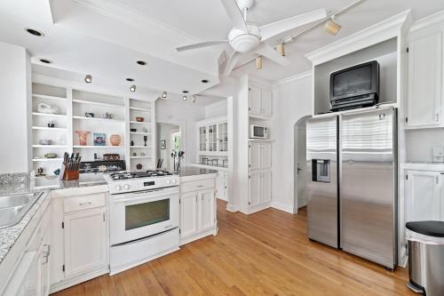 a kitchen with white cabinets and a stainless steel refrigerator at 5BR Atlanta Historic-Sleeps 10-Near Emory & CDC in Atlanta