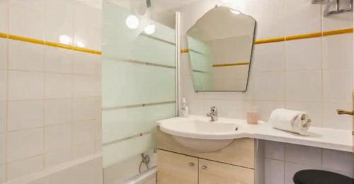 une salle de bain blanche avec un lavabo et un miroir dans l'établissement Confort & Calme au Centre de Marseille, à Marseille