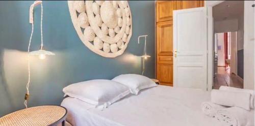 - une chambre avec un lit blanc et un mur bleu dans l'établissement Confort & Calme au Centre de Marseille, à Marseille
