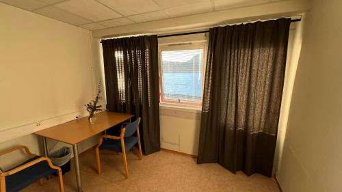 a dining room with a table and a window at Sea side stay in Sand in Åsen