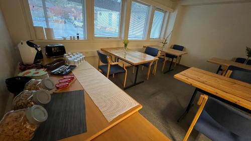 an empty room with tables and chairs and windows at Sea side stay in Sand in Åsen