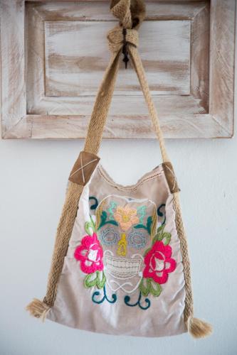 a sugar skull bag hanging on a wall at LiveTulum in Tulum