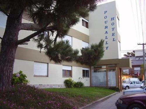 un edificio con un árbol delante en Hotel Pourally, en Villa Gesell