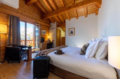una camera da letto con un letto, una scrivania e una sedia di Hôtel Saint-Martin a Saint-Martin-de-Belleville