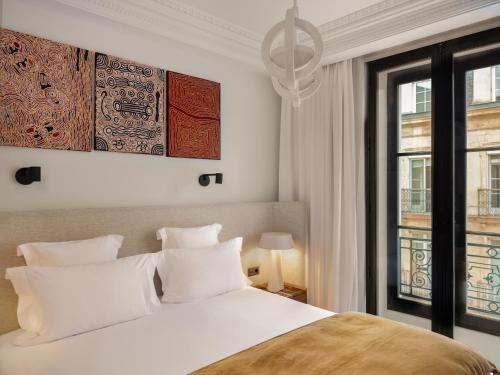 a bedroom with a white bed and a window at Balthazar Hotel & Spa Rennes - MGallery Collection in Rennes