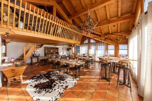 un ristorante con soffitti in legno, tavoli e sedie di Hôtel Saint-Martin a Saint-Martin-de-Belleville